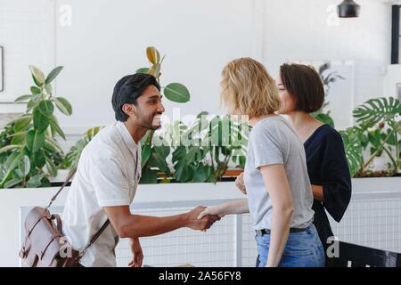 Unternehmer und Unternehmerin Händeschütteln im Büro Stockfoto
