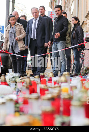 18. Oktober 2019, Sachsen-Anhalt, Halle: Reiner Haseloff (4. von links, CDU), Ministerpräsident von Sachsen-Anhalt, und Izzet Cagac (3. von rechts), Betreiber des Kiez Döner Kebab, stehen vor der Blumen und Kerzen vor dem Laden. Haseloff und Beauftragter der Bundesregierung für die Opfer haben die Kiez-Döner, die von den Rechten Terroranschlag betroffenen besucht wurde. Beide haben die Eigentümer der Snackbar und seinen Mitarbeitern für ihre Unterstützung zugesichert. Am 9. Oktober die Deutsche Stephan B., schwer bewaffnet, hatte zunächst versucht, eine Synagoge zu durchdringen. Wenn sein Plan scheiterte, schoß er 40 Jahr Stockfoto