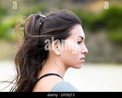Junge weibliche surfer Blick vom Strand, Kopf und Schulter Seitenansicht, Victoria, Australien Stockfoto