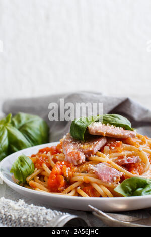 Spaghetti mit Stücken von frischem Thunfisch, Tomaten und Kapern Nahaufnahme Stockfoto
