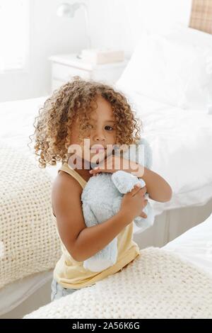 Kleines Mädchen kuscheln Plüschtier im Schlafzimmer Stockfoto