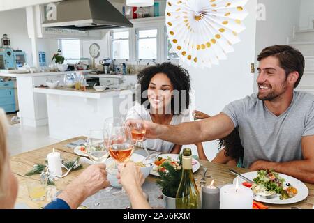 Familie toasten Wein am Esstisch in Home Party Stockfoto