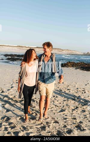 Paar nehmen zu Fuß am Sandstrand Stockfoto