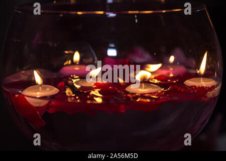 Rote Kerze leuchtet in einem großen glassess für Valentinstag. Stockfoto