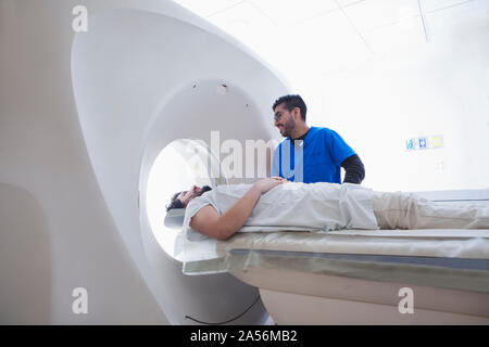 Jungen männlichen Röntgentechniker Betriebssystem CT-Scanner in der Radiologie Stockfoto