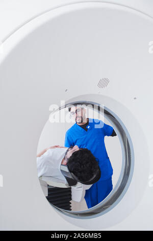 Jungen männlichen Röntgentechniker operative CT-Scanner in der Radiologie Stockfoto