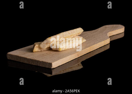 Gruppe von drei ganzen trockenen pflanzlichen Chip von Taro auf kleinen hölzernen Schneidebrett auf schwarzem Glas isoliert Stockfoto