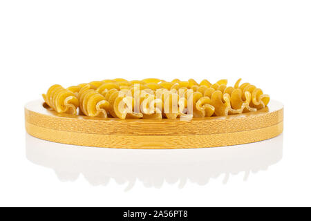 Menge ganz trocken braun Vollkorn fusilli auf Bambus Untersetzer auf weißem Hintergrund Stockfoto