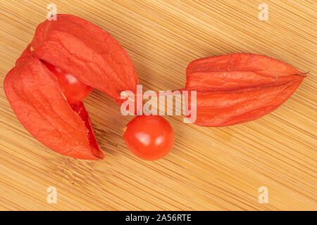 Gruppe von drei ganzen frischen Orange physalis flatlay auf hellem Holz. Stockfoto