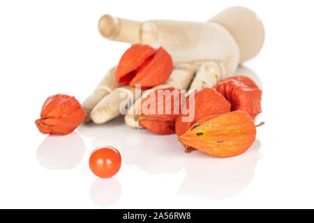 Menge ganze Frische orange Physalis mit hölzernen Hand auf weißem Hintergrund Stockfoto