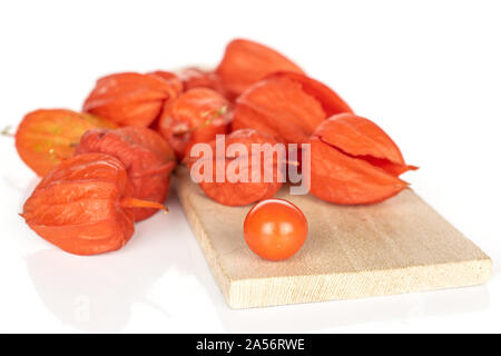 Menge ganze Frische orange Physalis auf Holz Schneidebrett auf weißem Hintergrund Stockfoto