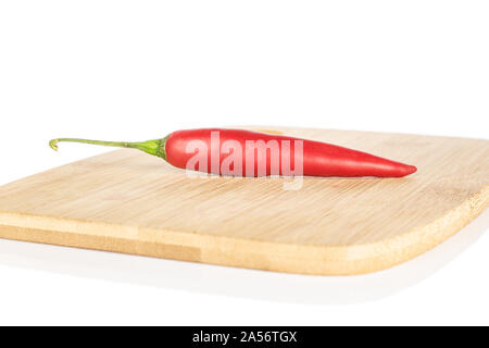 Ein ganzes glänzend Hot red chili Cayenne auf Bambus Schneidbrett auf weißem Hintergrund Stockfoto