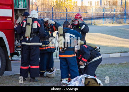 Gruppe von Feuerwehrleuten auf Gasmasken und Vorbereitung auf die Feuer löschen. Stockfoto