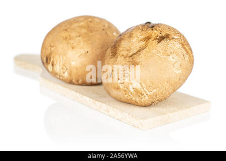 Gruppe von zwei ganze Frische braune Champignon Champignon auf Holz Schneidebrett auf weißem Hintergrund Stockfoto