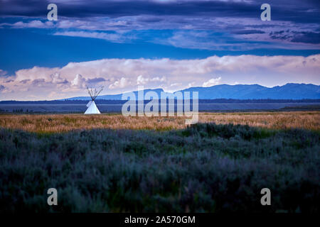 Tipi im freien Feld mit Bergen im Hintergrund. Stockfoto