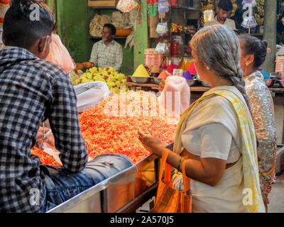 MYSURU (MYSORE), Karnataka/Indien - vom 13. Februar 2018: eine indische Frau entscheidet, Girlanden im Flower ausgeht, Devaraja market, Mysore, Karnataka. Stockfoto