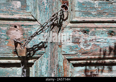 Ein Vorhängeschloss und Kette auf eine alte hölzerne Tür Stockfoto