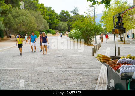 Athen Griechenland 16. Juli2019; Touristen zu Fuß rund um die Promenade rund um Base und auf die Akropolis und letzten Essen in selektiven Fokus abgewürgt. Stockfoto