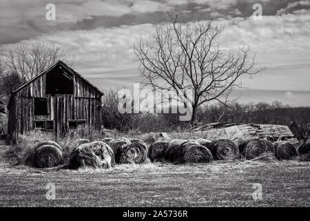 Bauernhof mit Silo und Heuballen aufgegeben. Stockfoto