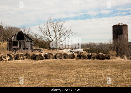 Bauernhof mit Silo und Heuballen aufgegeben. Stockfoto