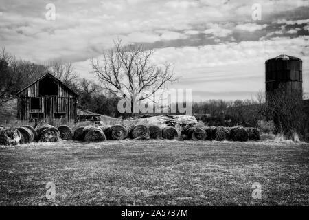 Bauernhof mit Silo und Heuballen aufgegeben. Stockfoto