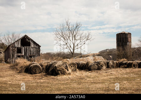 Bauernhof mit Silo und Heuballen aufgegeben. Stockfoto