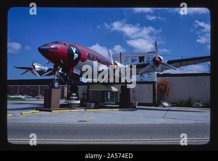 Dorfplatz, Crash, New Orleans, Louisiana Bild Beschreibung: Crash war eine Bar (zu verschiedenen Zeiten auch ein Restaurant &/oder Disco Dance Club) in Metairie, Louisiana in der Nähe der Kreuzung der Causeway Boulevard & Interstate 10. Es kennzeichnete den Körper eines pensionierten Lockheed Constellation Flugzeug, eine Neuheit, die es einem lokalen Wahrzeichen. Es öffnete sich 1973, und nicht lange, nachdem dieses Foto wurde im Jahr 1982 übernommen. Stockfoto