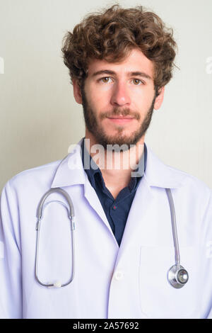 Gesicht der jungen bärtigen Mann Arzt mit lockigem Haar Stockfoto