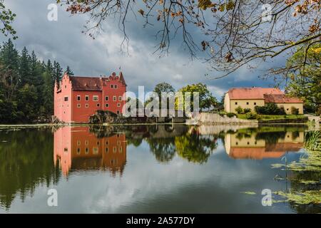 Cervena Lhota, Tschechien - 28. September 2019: Blick auf den berühmten roten Schloss steht auf einem Felsen in der Mitte eines Sees. Sonnigen Tag und blauer Himmel. Stockfoto