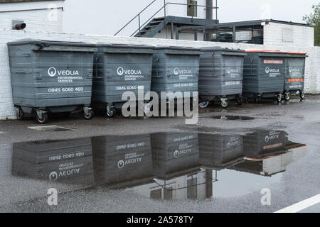 Reihe von Veolia Abfallbehälter und recycling Bins in einer Pfütze spiegelt, Großbritannien Stockfoto