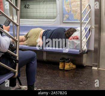 Ein obdachloser Mann schläft in einer U-Bahn in New York am Dienstag, 8. Oktober 2019. (© Richard B. Levine) Stockfoto