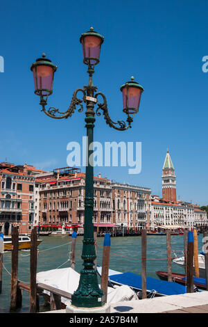 Die Grand Canal und der Campanile di San Marco, vom Campo della Salute, Dorsoduro Venedig, Italien: aufwändige Lampe-Post im Vordergrund. Stockfoto