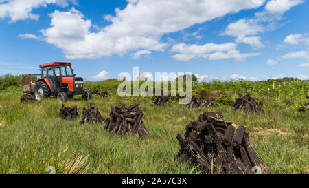 Alten roten Traktor in einem Bereich der Trocknung Moor, ländlichen Irland Landschaft Stockfoto