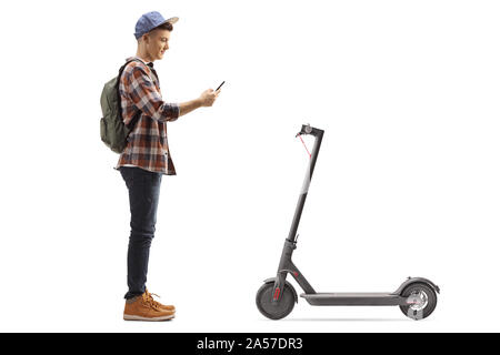 Volle Länge Profil Schuß eines Jugendlichen männlichen Kursteilnehmer Vermietung einer elektrischen scooter mit einem Mobiltelefon Anwendung auf weißem Hintergrund Stockfoto