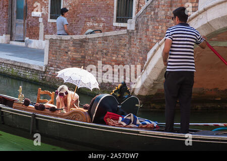 Gondel mit Glamorous Blonde Fluggast ein Sonnenschirm, Rio del Malcanton, Santa Croce, Venedig, Italien Stockfoto