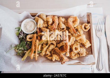 Frito misto (zerschlagene frittierte Meeresfrüchte abwechslungsreiches) serviert auf einem Holz- Fach in einem Restaurant, selektive konzentrieren. Stockfoto