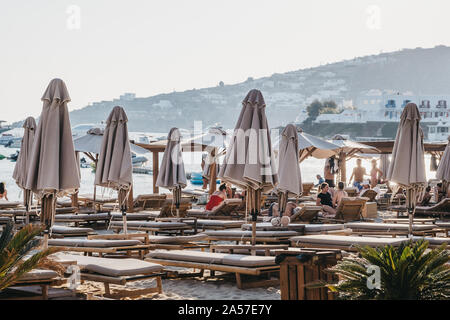 Mykonos, Griechenland - 19 September, 2019: Reihen von Liegestühlen und Sonnenschirmen auf Platis Gialos, einem beliebten Strand an der Südküste von Mykonos. Selektive konzentrieren. Stockfoto