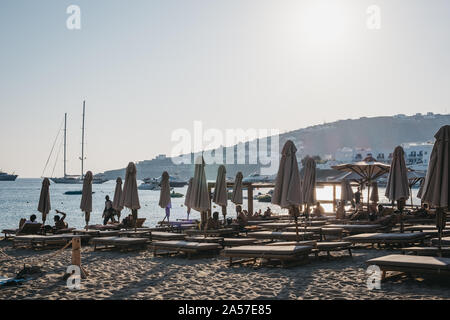 Mykonos, Griechenland - 19 September, 2019: Reihen von Liegestühlen und Sonnenschirmen auf Platis Gialos, einem beliebten Strand an der Südküste von Mykonos. Selektive konzentrieren. Stockfoto