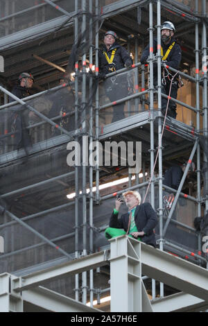 Westminster, London, UK, 18. Okt 2019. Ein Klima Demonstrant vor dem Aussterben Rebellion (XR) hat kletterte Big Ben auf halbem Weg, zwei Banner montiert und sitzt auf einige Gerüste auf der southeatern Ecke der Elizabeth Tower, allgemein bekannt als Big Ben, das Parlamentsgebäude. Polizei Verhandlungsführer Erscheinen auf der Szene gerade über Ihn zu werden. Credit: Imageplotter/Alamy leben Nachrichten Stockfoto