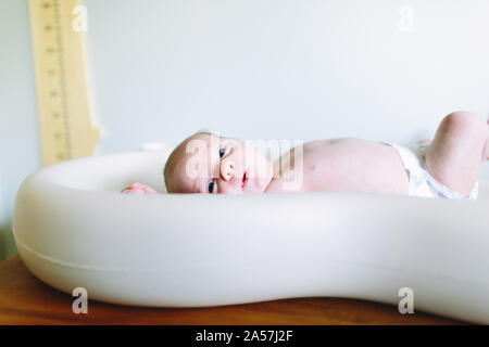 Seitenansicht eines neugeborenen Jungen auf einem Wickeltisch Stockfoto