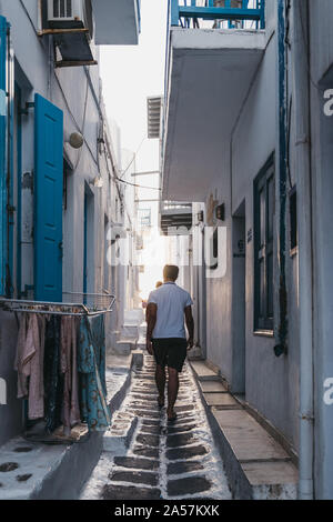 Mykonos, Griechenland - 23. September 2019: Rückansicht von Menschen zu Fuß auf einer schmalen Straße in Hora (Mykonos Stadt), die Hauptstadt der Insel und einer der Besten Stockfoto