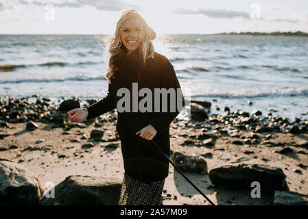 Frau lachend am Strand im Winter Stockfoto