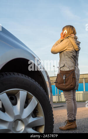 Frau nicht die Aufmerksamkeit auf den Verkehr zahlen, weil sie auf das Telefon. Stockfoto