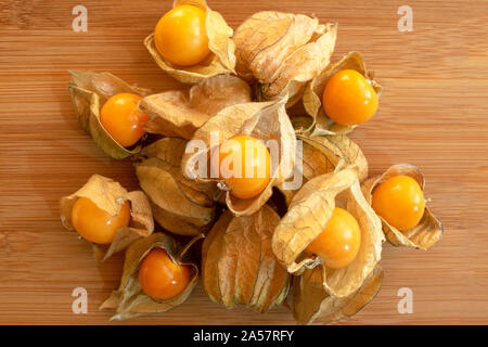 Stapel der goldenen Beeren auf hellem Holztisch isoliert. Physalis Früchte. Golden Beeren. Stockfoto