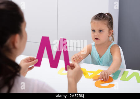 Süße kleine Mädchen an Logopädin Office Lernen der Buchstaben P Stockfoto