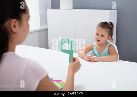 Süße kleine Mädchen an Logopädin Office Lernen der Buchstaben P Stockfoto