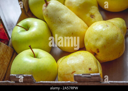 Piers und Äpfel, Herbst Ernte. Grüne Äpfel und gelb Piers in einer Box schließen. Stockfoto