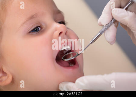 Nahaufnahme der pädiatrischen Zahnarzt Prüfung ein wenig Girl's Zähne in der Zahnärzte Stockfoto