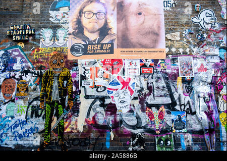 Einen Blick auf eine Wand mit politischen Plakate gefüllt. als Brexit Frist droht, neue Wandbilder und Einfügen-ups auf den Straßen von London angezeigt werden. Brick Lane, im East End von London, ist einer der beliebtesten Orte alle Art von Kunst um die Brexit zu finden. Auch im berühmten Stadtteil Shoreditch, Touristen zu Fuß und nehmen Sie Fotos um diese politische Street Art. Stockfoto