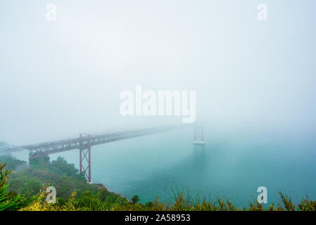 Blick auf den Nebel an der Ponte 25 de Abril ist eine Hängebrücke über den Fluss Tejo, Portugal Stockfoto